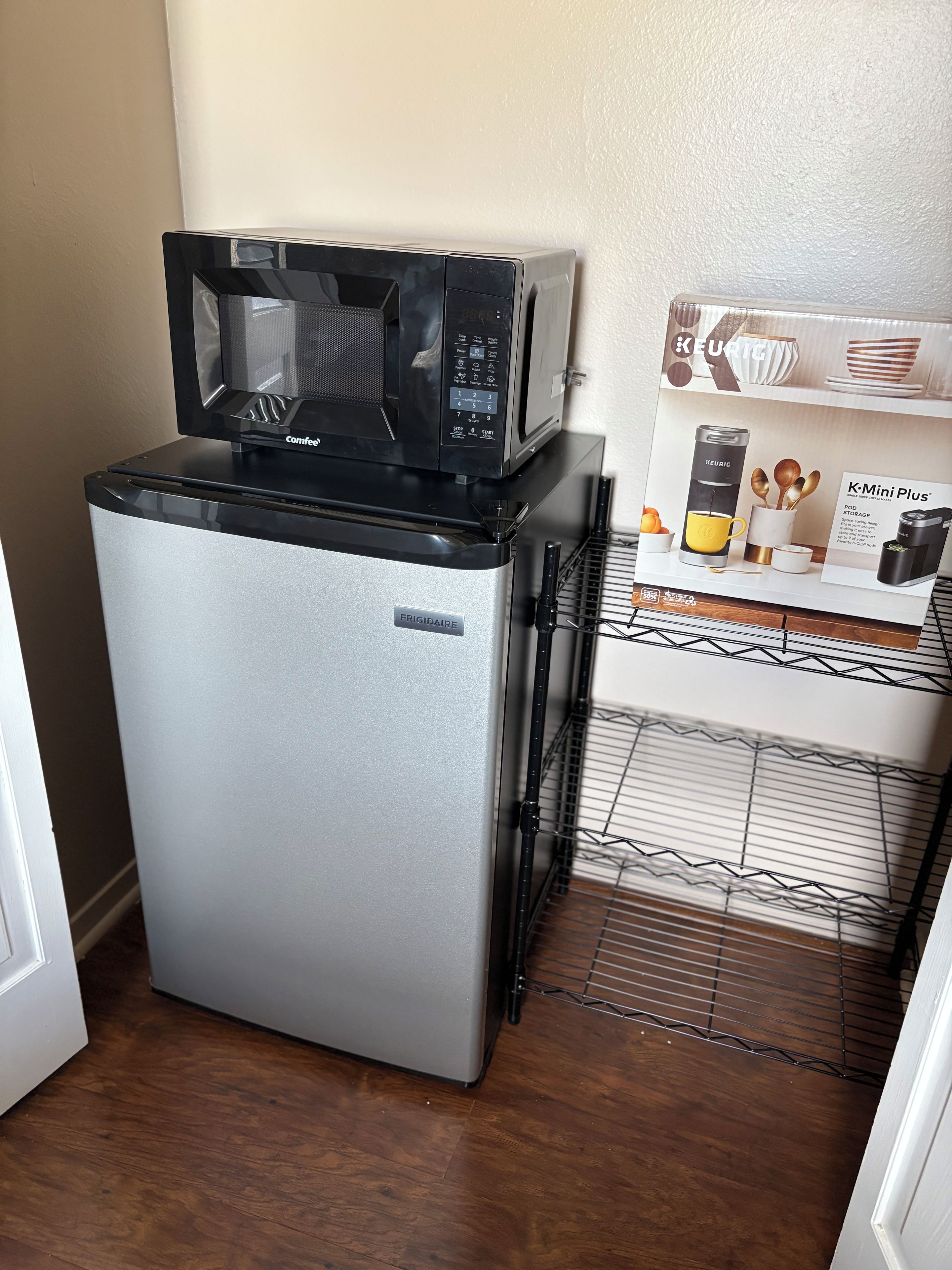 A compact kitchenette with a refrigerator, a microwave, and a coffee maker.