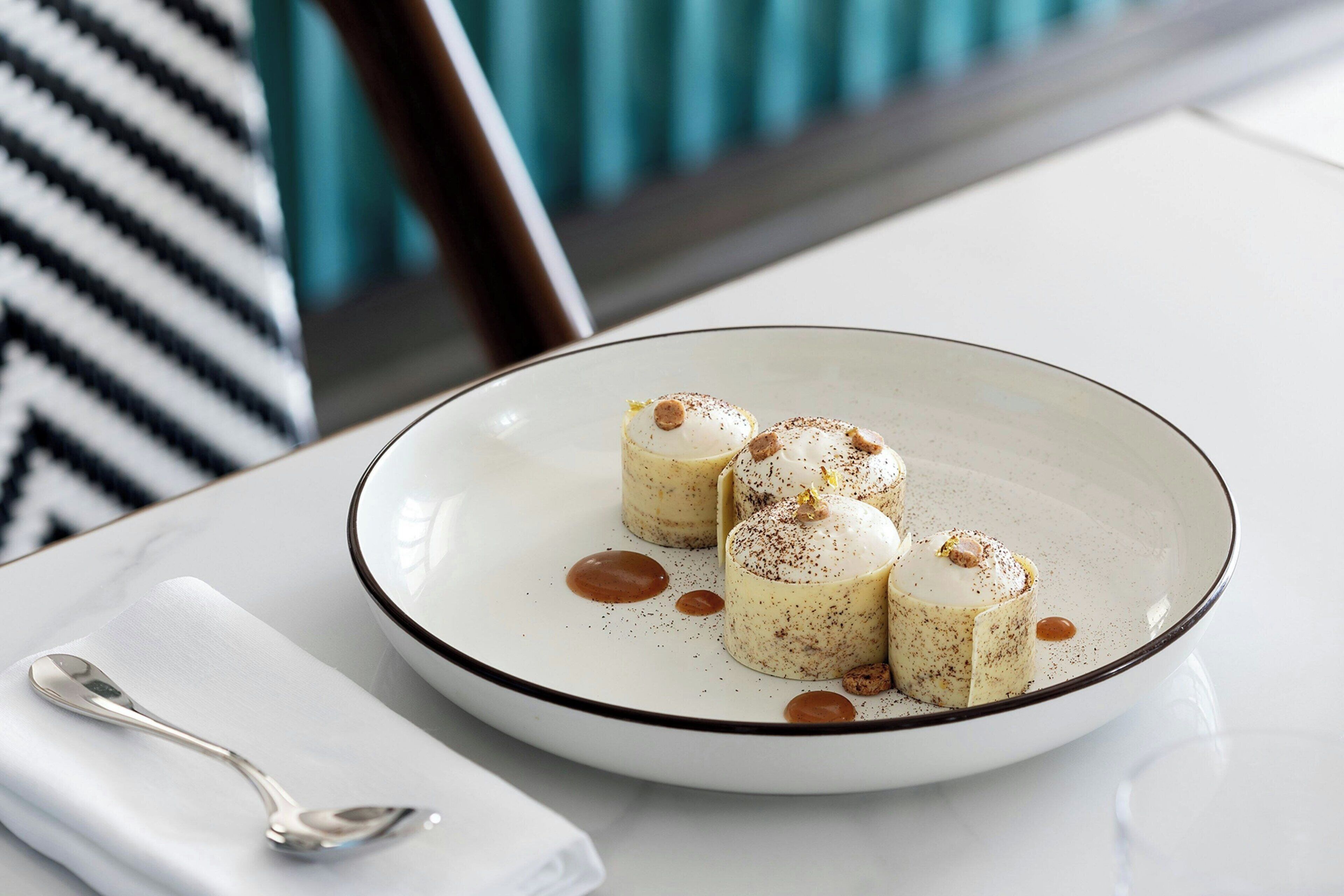 A plate of dessert with a spoon on a white napkin.