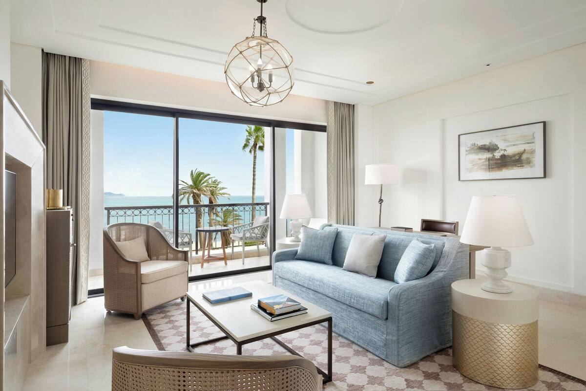 Un salon spacieux avec un balcon, un canapé, une table basse et un téléviseur.
