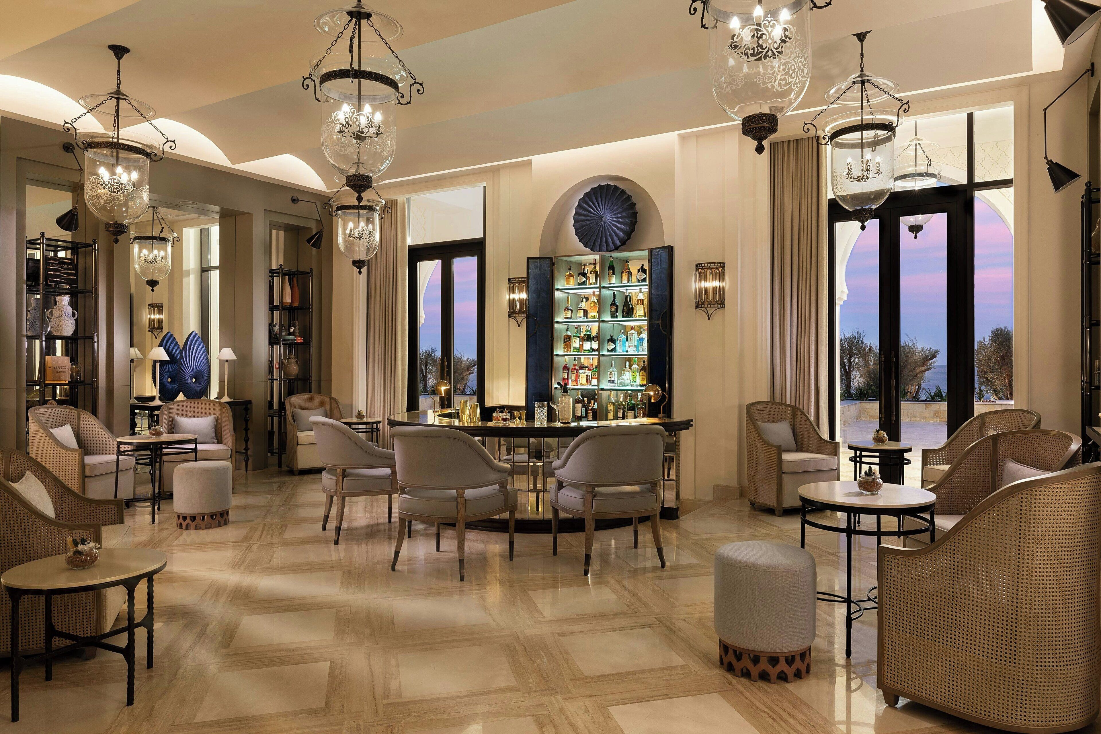 A spacious lounge area with a bar, comfortable seating, and a large window offering a view of the outdoors.