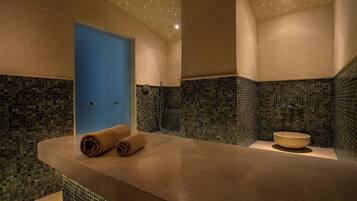 Un baño moderno con una bañera grande, una puerta azul y paredes con mosaicos.