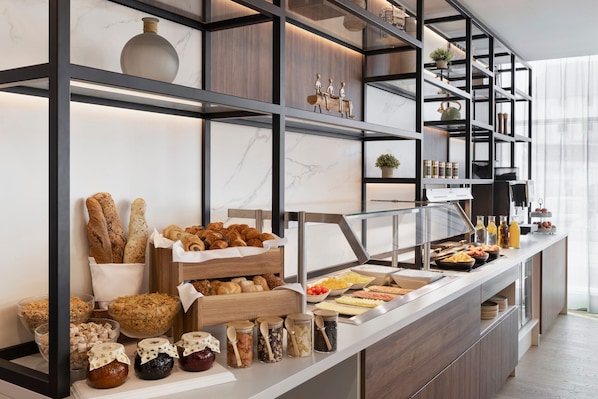 Un bufé con diferentes opciones de comida y un diseño interior moderno.