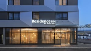 Un bâtiment moderne doté d’une grande façade en verre, d’une enseigne indiquant « Residence Inn by Marriott » et d’une entrée bien visible.