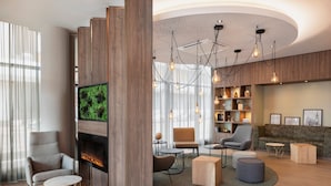 Un salon moderne doté d’une cheminée, de sièges confortables et d’un mur d’accent en bois.