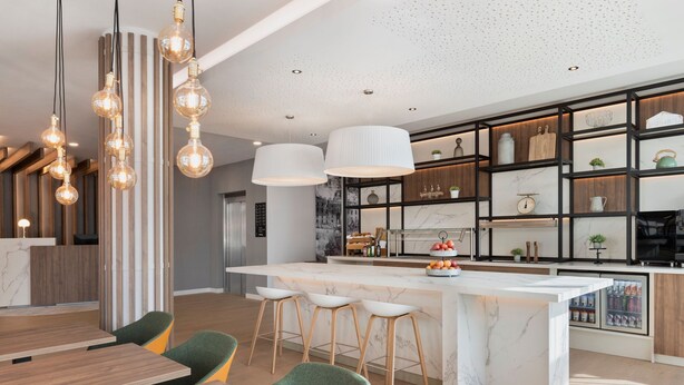 Une cuisine moderne dotée d’un îlot en marbre, de luminaires suspendus et de tabourets de bar.