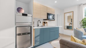 A modern kitchen with a built-in microwave, a stainless steel refrigerator, and a wooden cabinet.