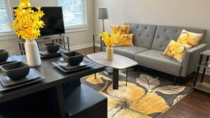 A modern living room with a grey sofa, a coffee table, and a decorative rug. - Serenity 1 King Bed/Pool (Moseley)