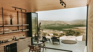 A modern kitchen with a large window overlooking a scenic landscape. - MIRA Earth Studios (Valle de Guadalupe)