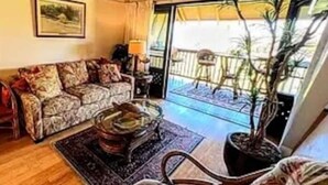 A living room with a sofa, a coffee table, and a potted plant. - 1-bedroom condo in Maunaloa, just 10 minutes from the beach (Maunaloa)