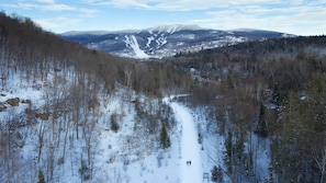 A snowy mountain landscape with a ski trail and a chairlift. - Maison Napoleon (Mont-Tremblant)