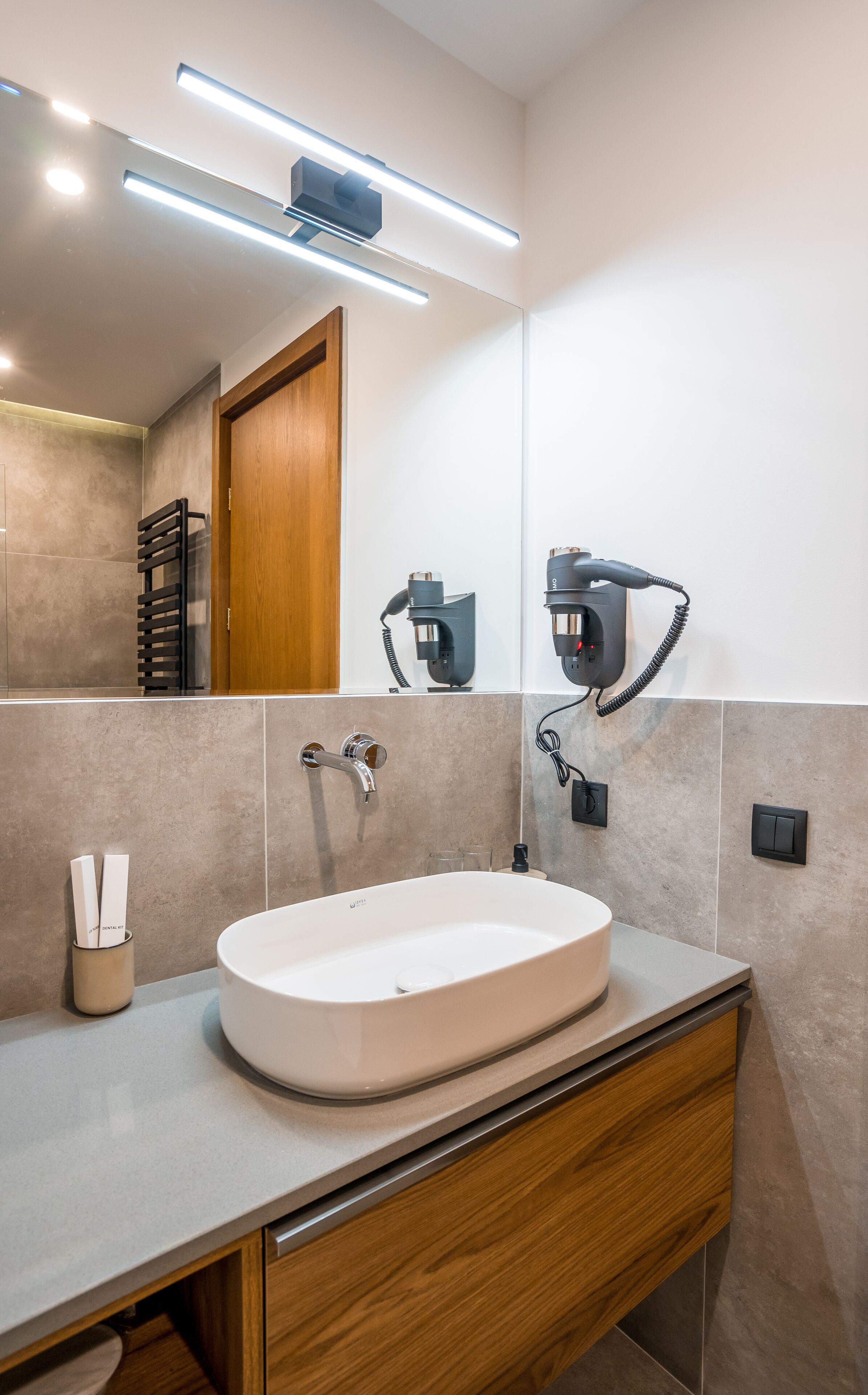 A modern bathroom with a freestanding sink, a mirror, and a towel rack.