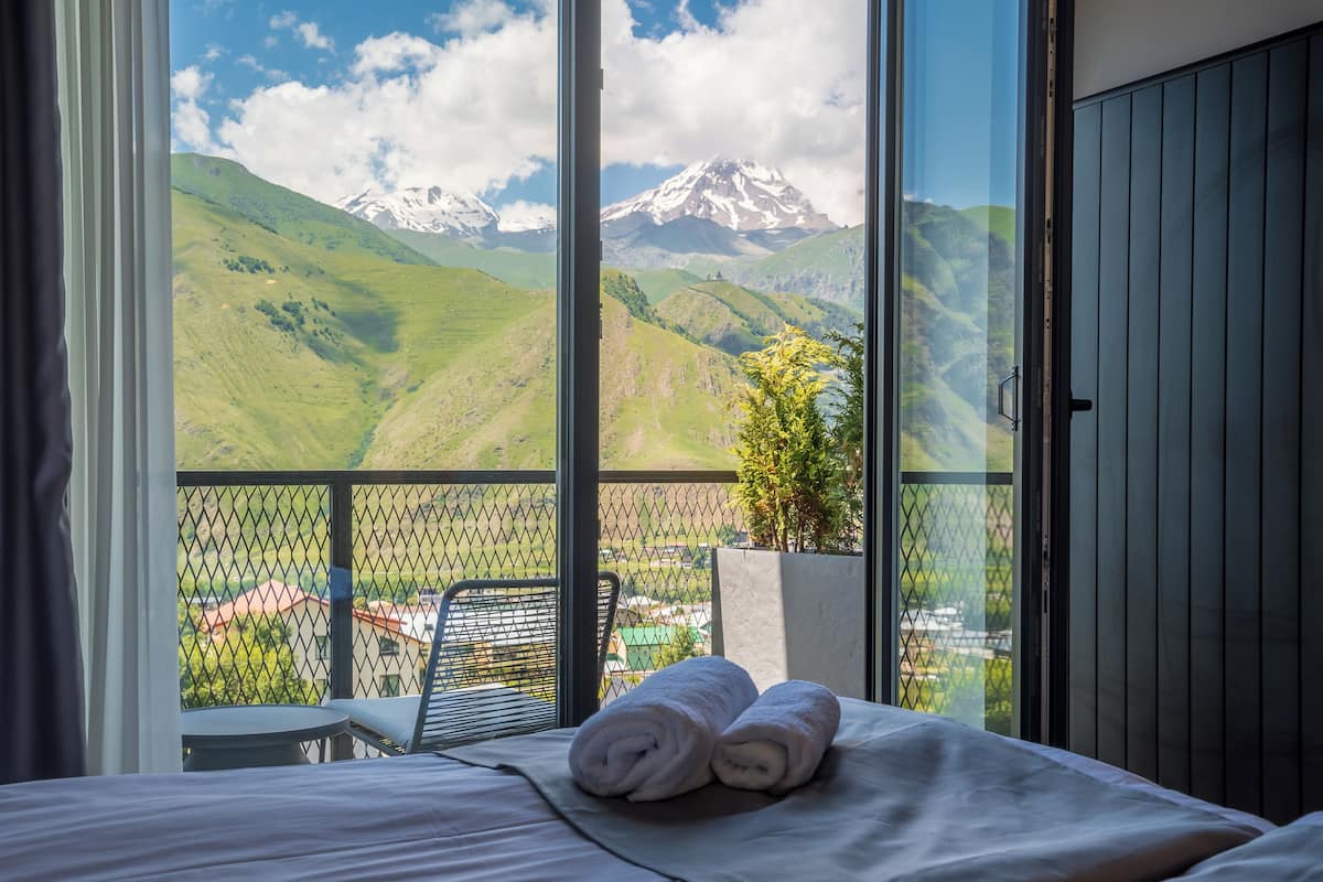 Une chambre d’hôtel dotée d’une grande fenêtre donnant sur les montagnes.