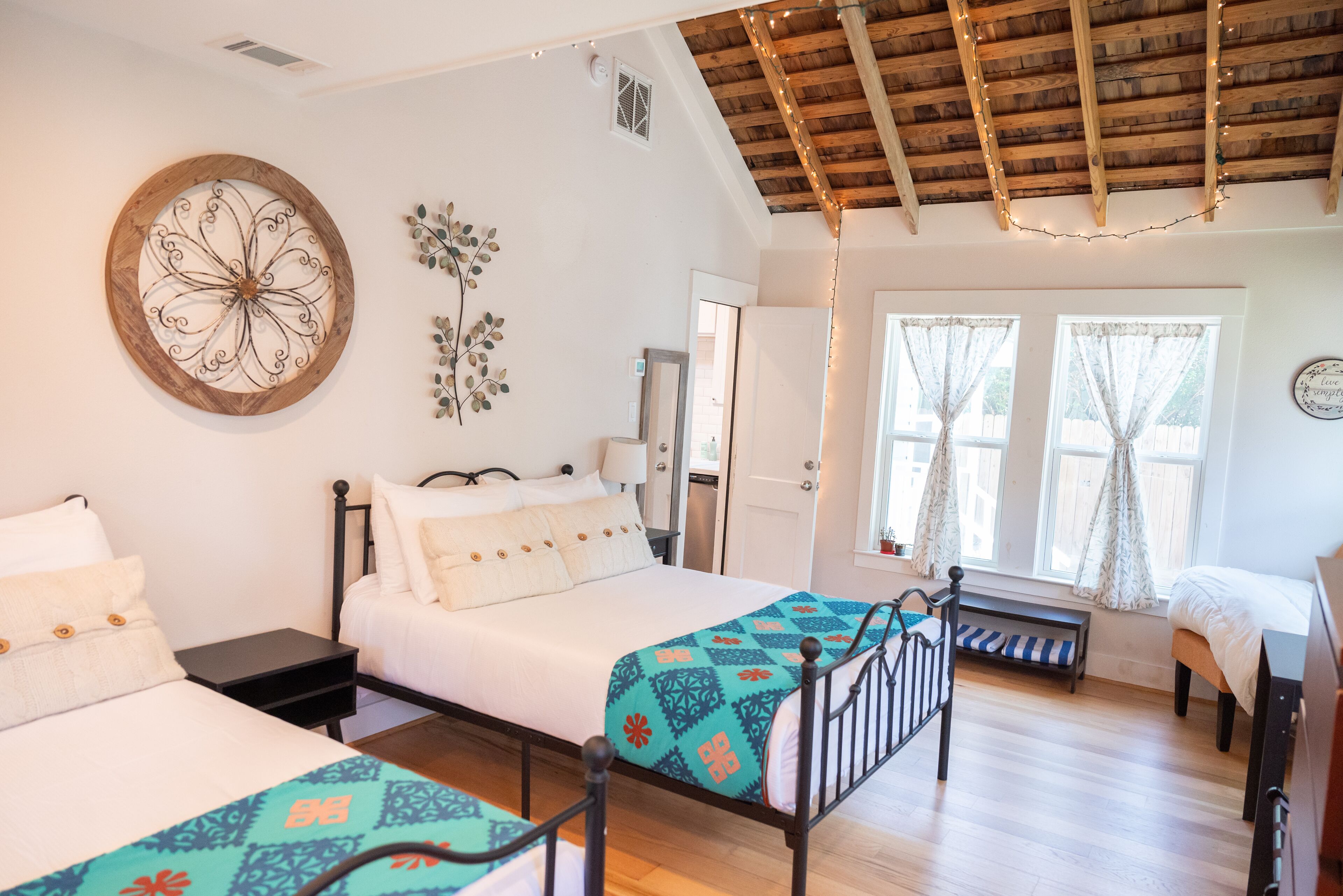 Un dormitorio con dos camas, techo de madera y un gran adorno en la pared.