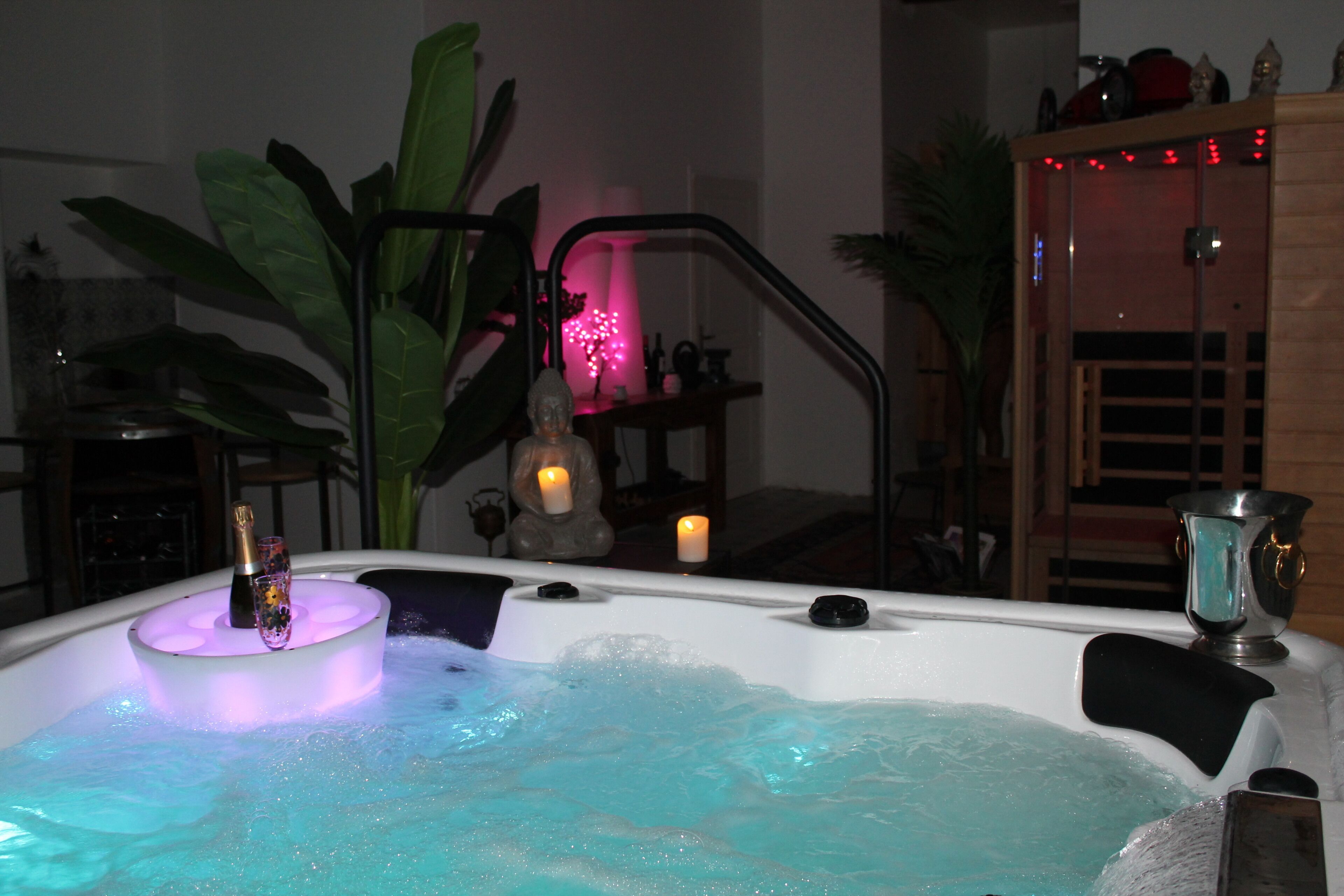 Un jacuzzi con burbujas, una botella y una vela.