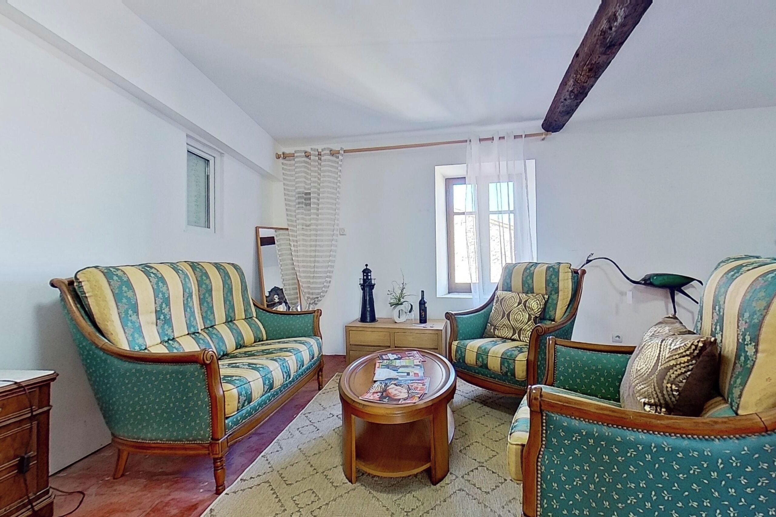 Ein Wohnzimmer mit zwei grün gestreiften Sofas, einem Holztisch und einem kleinen Beistelltisch.