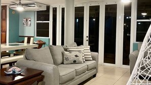 A living room with a sofa, a coffee table, and a ceiling fan. - #25 5,000 SqFt Penthouse w/ Private Rooftop Loft (Cabo Rojo)