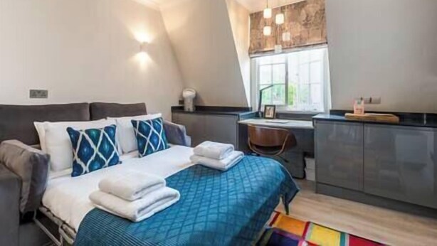 Une chambre à coucher avec un lit, un bureau et une fenêtre.