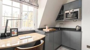 Une cuisine moderne équipée d’un four encastré, d’un four à micro-ondes et d’une fenêtre donnant sur la ville.