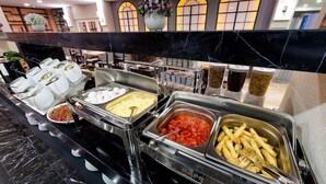 A buffet with various food items including eggs, potatoes, and French fries. - Four Sides Sisli (Istanbul)