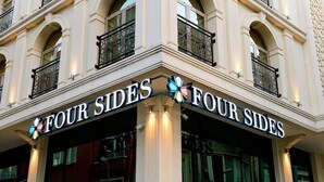 A building with a sign reading "FOUR SIDES" and a logo with four colored flowers. - Four Sides Sisli (Istanbul)