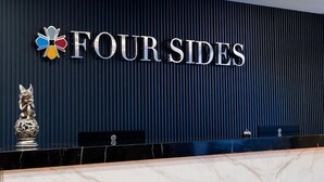A reception desk with a dark blue wall and the text "FOURSIDES" in white letters. - Four Sides Sisli (Istanbul)