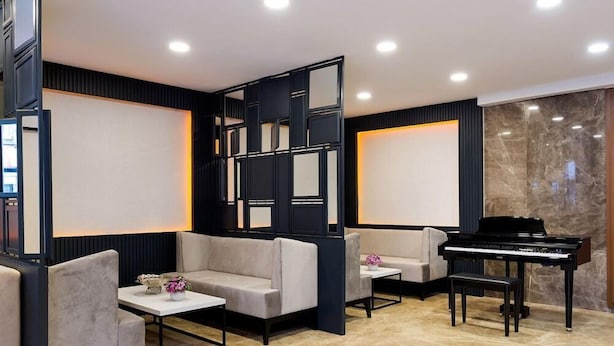 A modern living room with a piano, sofas, and a decorative wall panel. - Four Sides Sisli (Istanbul)
