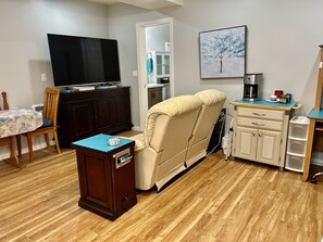Enjoy a compact living space with a flat-screen TV, dining area, and kitchenette, perfect for self-service meals.
