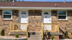 A two-story brick house with a front porch, two garage doors, and a small front yard. - Central Retreat C, NEW Family and Pet Friendly (Lebanon)