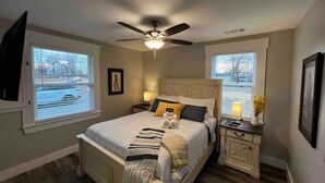 A bedroom with a bed, nightstands, a ceiling fan, and windows with blinds. - Central Retreat C, NEW Family and Pet Friendly (Lebanon)
