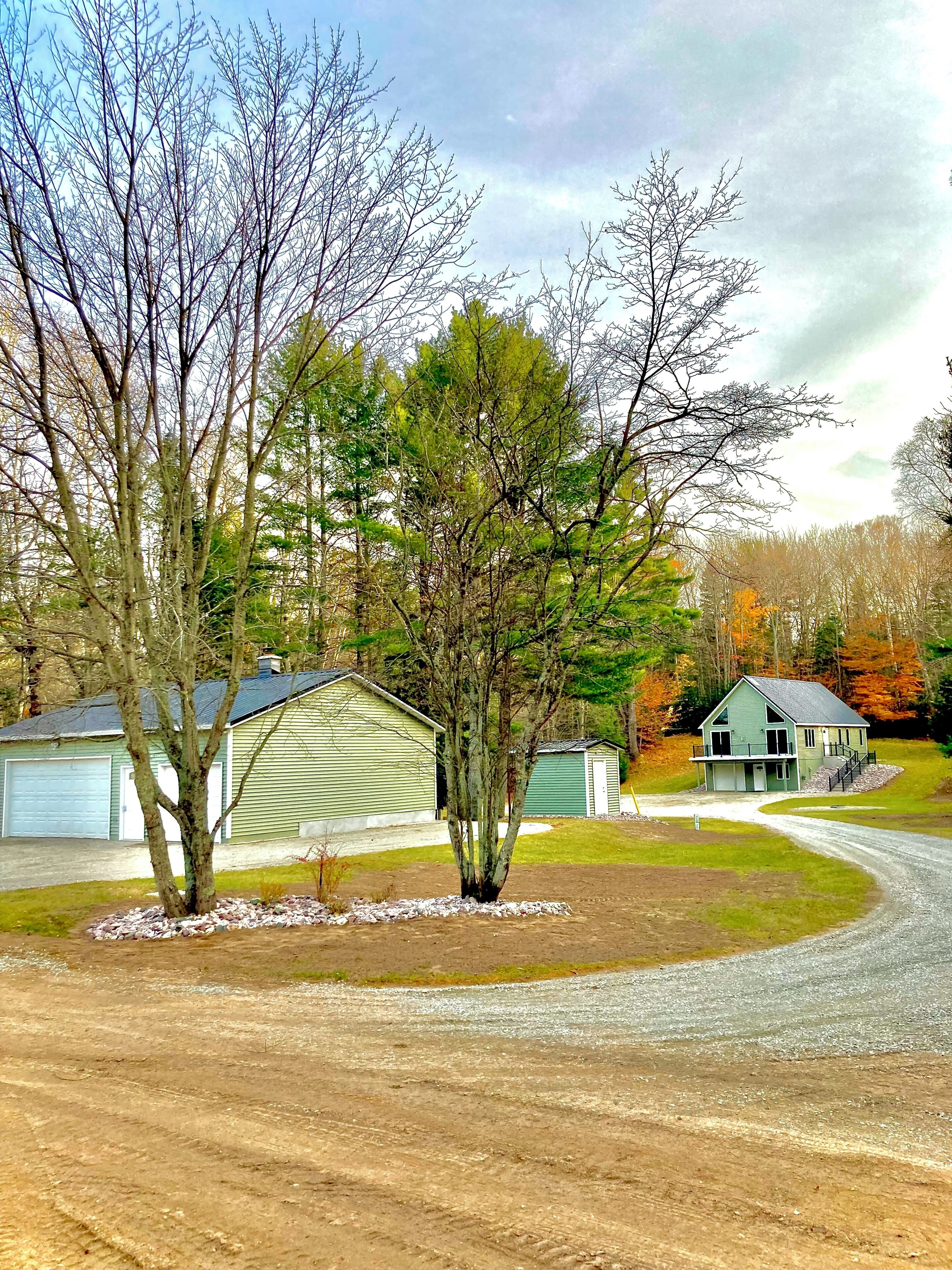 A residential area with a green house, a garage, and a driveway.