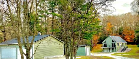 A residential area with a green house, a garage, and a driveway.