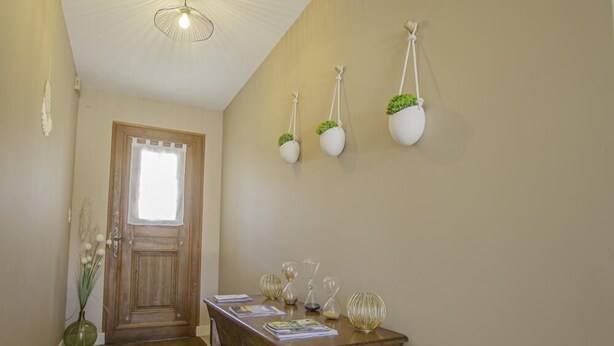A wooden dining table with a vase and glassware, a wooden door, and wall-mounted planters. - Maison des 3 Lacs - CHAVANGES (CHAVANGES)