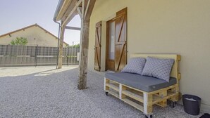 A rustic outdoor seating area with a wooden bench and a small table, surrounded by a gravel ground and a wooden fence. - Maison des 3 Lacs - CHAVANGES (CHAVANGES)