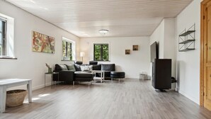 A modern living room with a sofa set, a TV, and a wooden ceiling. - Awesome home in Bække with kitchen (Bække)