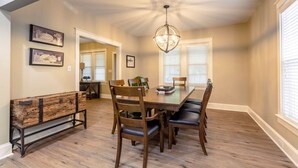 A dining room with a wooden table, chairs, a bench, and a chandelier. - The Queen Place*15min to Sight&Sound*King bed*BBQ (Gordonville)