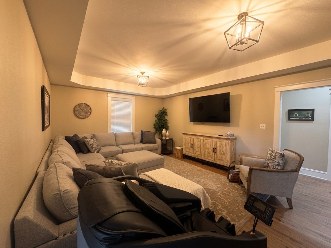 A living room with a sofa set, a television, and a cabinet.