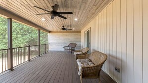 A covered porch with two wicker chairs, ceiling fans, and a view of trees. - The Queen Place*15min to Sight&Sound*King bed*BBQ (Gordonville)