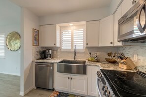 Enjoy cooking in this well-equipped kitchen with a stainless steel sink, dishwasher, and stovetop.