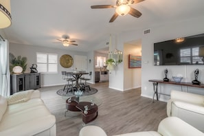 Relax in this stylish living area with a dining table, comfortable seating, and a large flat-screen TV.