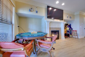 Un salon doté d’une cheminée, d’un téléviseur fixé au-dessus, et d’un espace de jeux pour enfants avec une structure colorée.