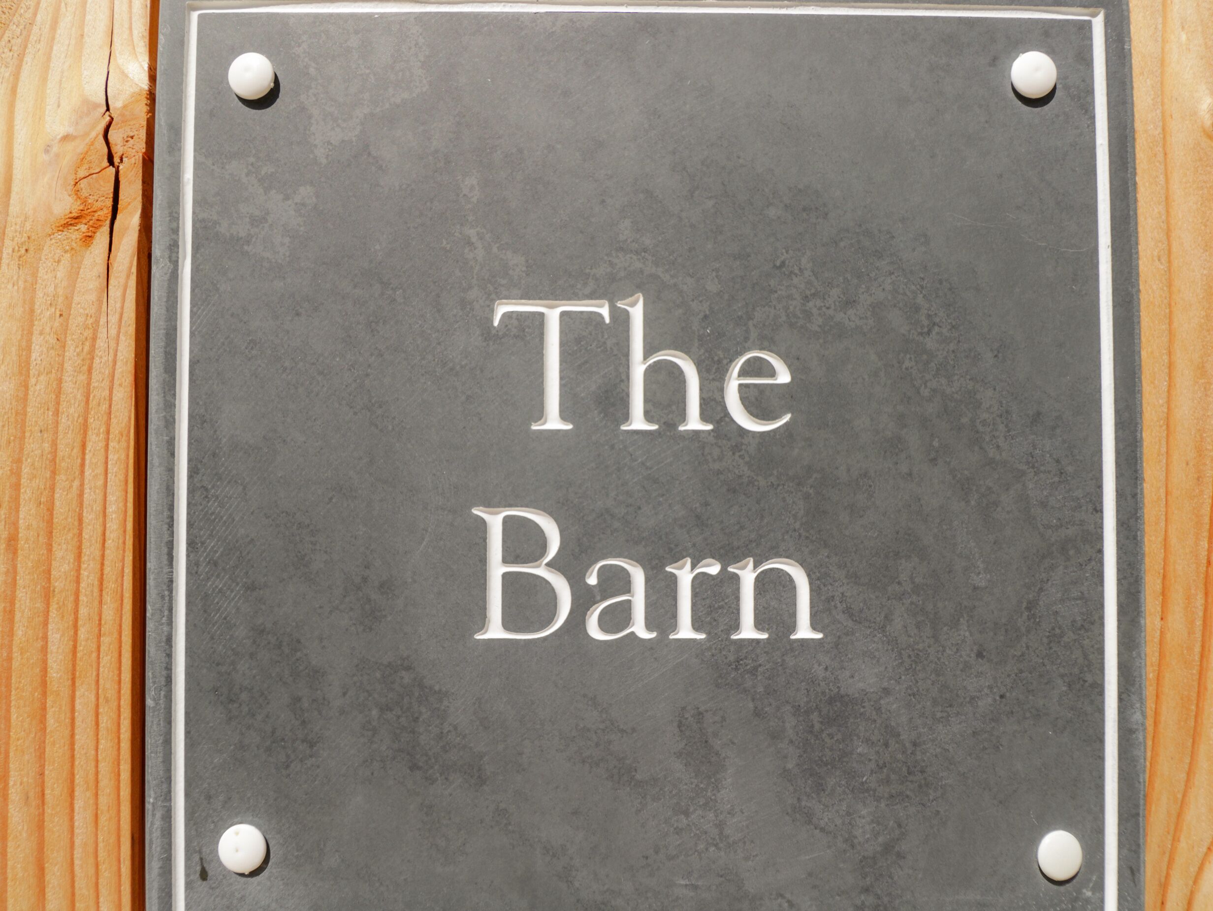 Seinälle on kiinnitetty kyltti, jossa lukee: ”The Barn”.
