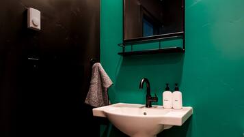 A bathroom with a white sink, a mirror, and two bottles of hand soap.