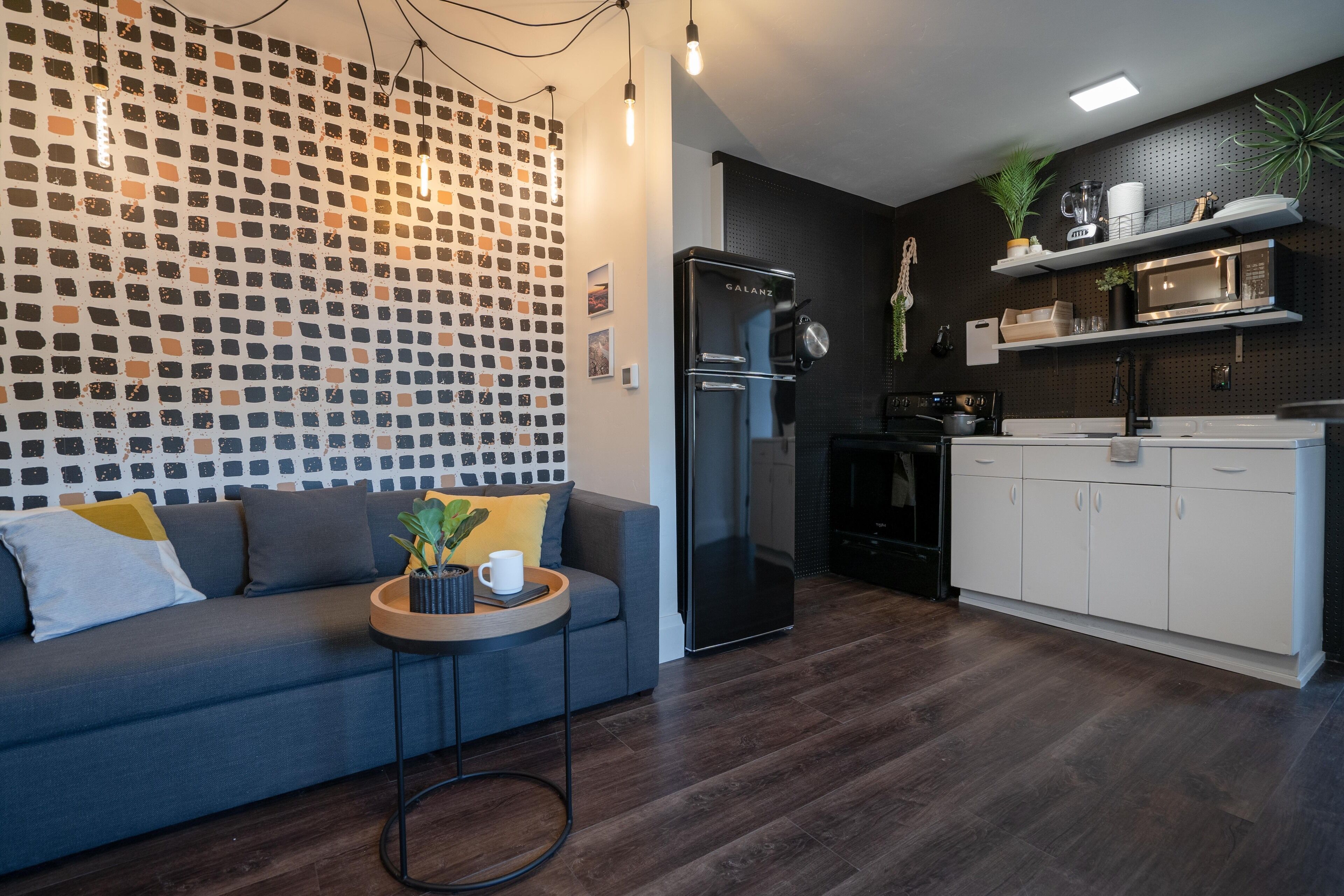 A modern kitchen with a built-in microwave, a refrigerator, and white cabinets.