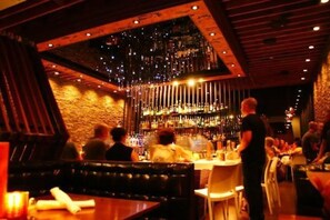 A bar area with a brick wall, wooden ceiling, and hanging lights. - Modern House In The Hills | Killer Location! (San Diego)