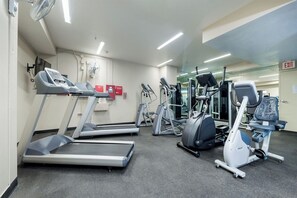 Une salle de sport équipée de tapis de course, d’appareils elliptiques et de vélos d’appartement.