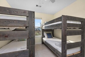Una habitación con literas, una ventana con vistas y un ventilador de techo.