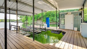 A covered dock with a swimming pool, wooden benches, and a boat ramp. - Waterfront Home w/ Views & Dock in Sunrise Beach! (Sunrise Beach)