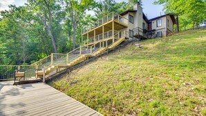 A house with a wooden deck and a staircase leading to a second-story balcony. - Waterfront Home w/ Views & Dock in Sunrise Beach! (Sunrise Beach)