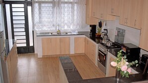 Ett modernt kök med träskåp, en inbyggd ugn och en diskho i rostfritt stål.