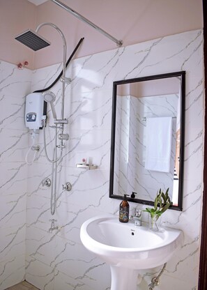 A bathroom with a white sink, a mirror, and a shower with a handheld showerhead. - Ilala House, Voi - Spacious 2 Bed, 2 Bath with parking,  7 mins to Tsavo East (Voi)